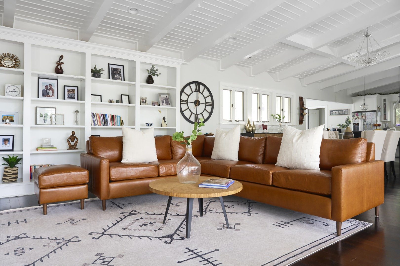 Caramel leather sectional with a round coffee table and built-in shelves