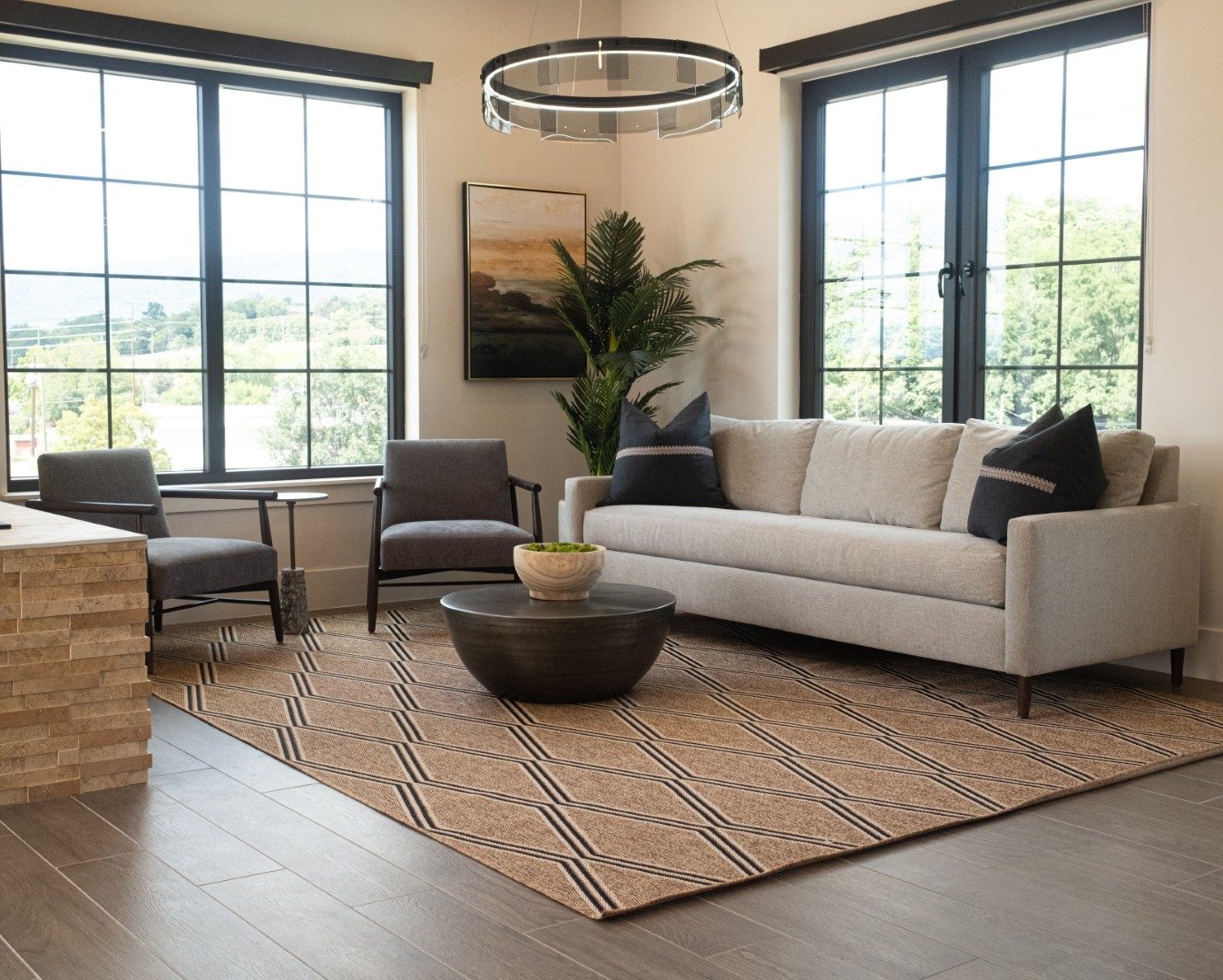 Cream sofa and gray armchairs beneath tall windows