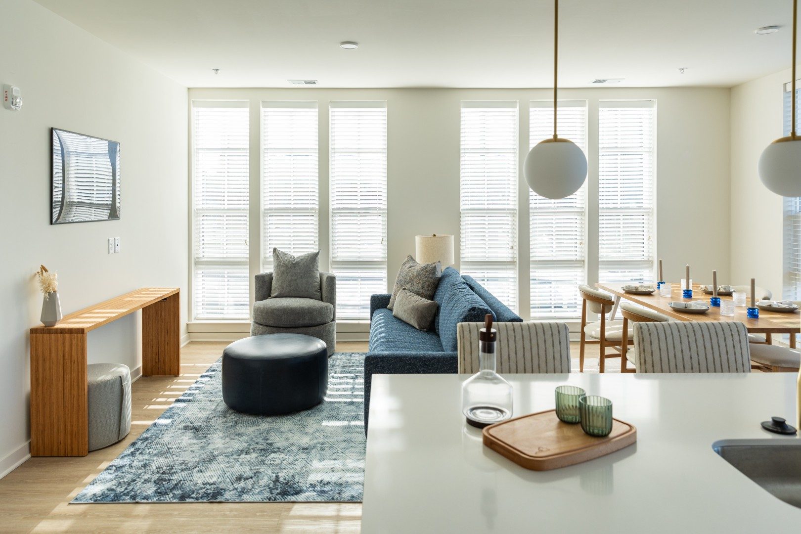Blue sofa near an open kitchen island with counter stools