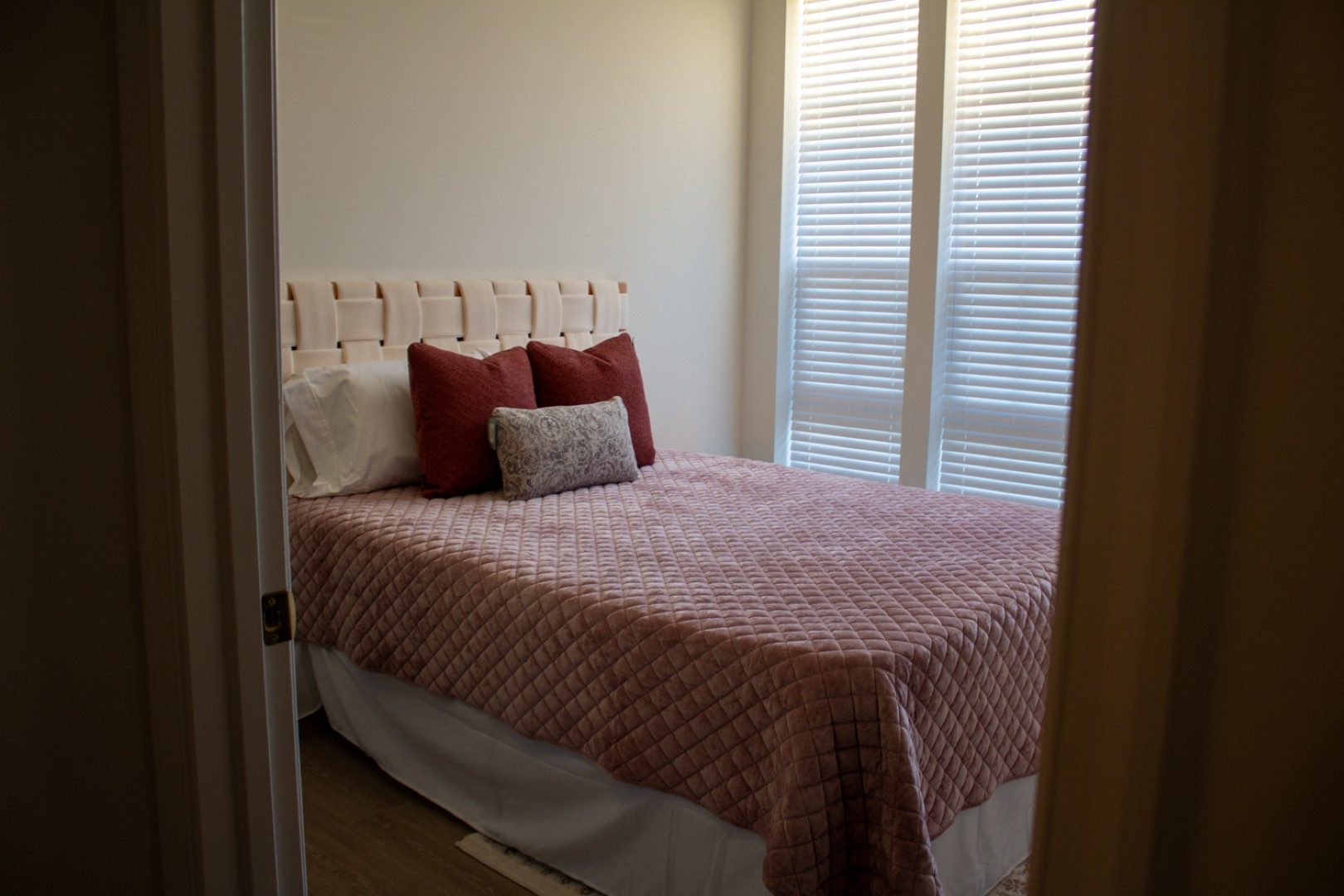 Bedroom with an upholstered headboard and red bedding