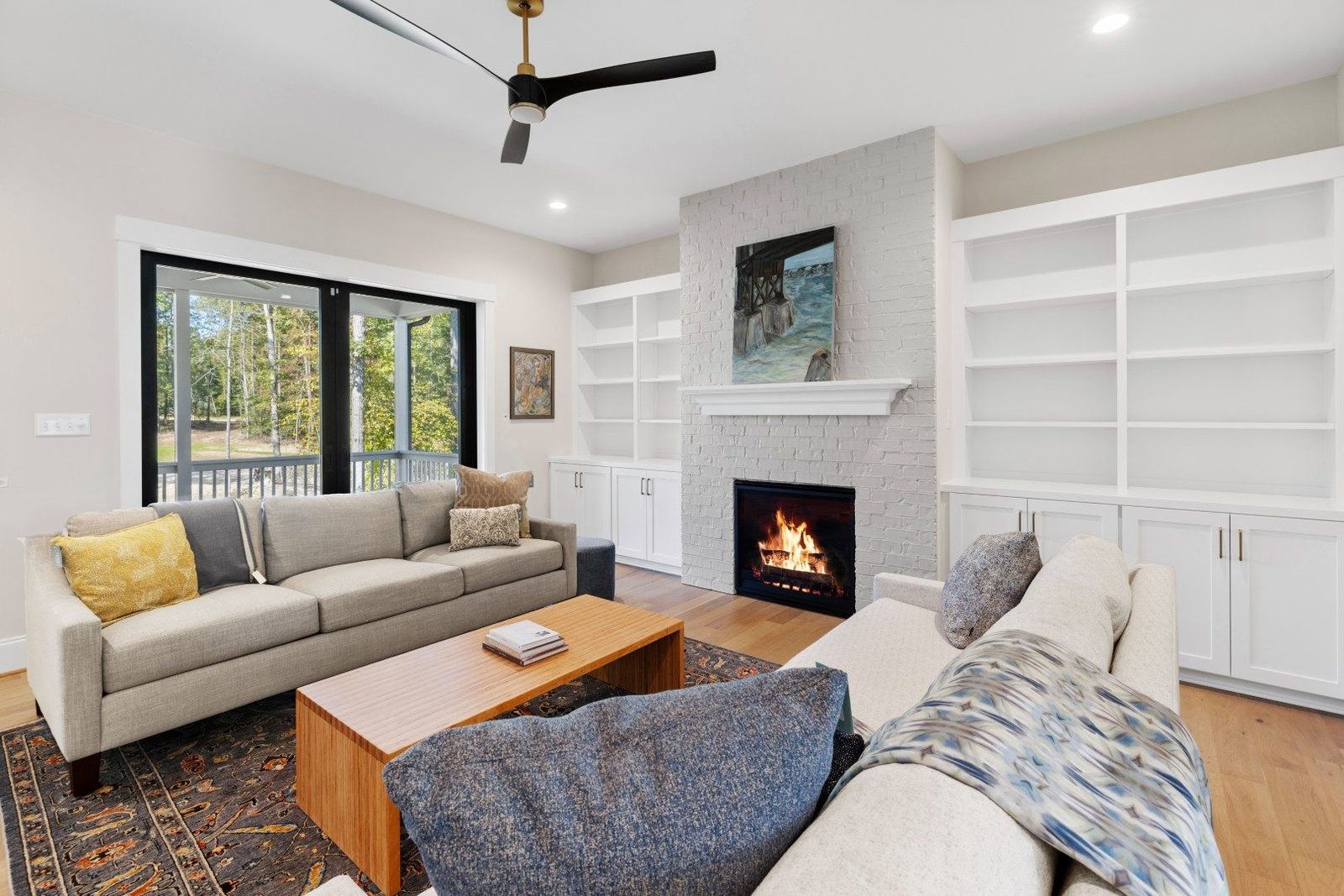 Gray sofa and wood coffee table beside a fireplace