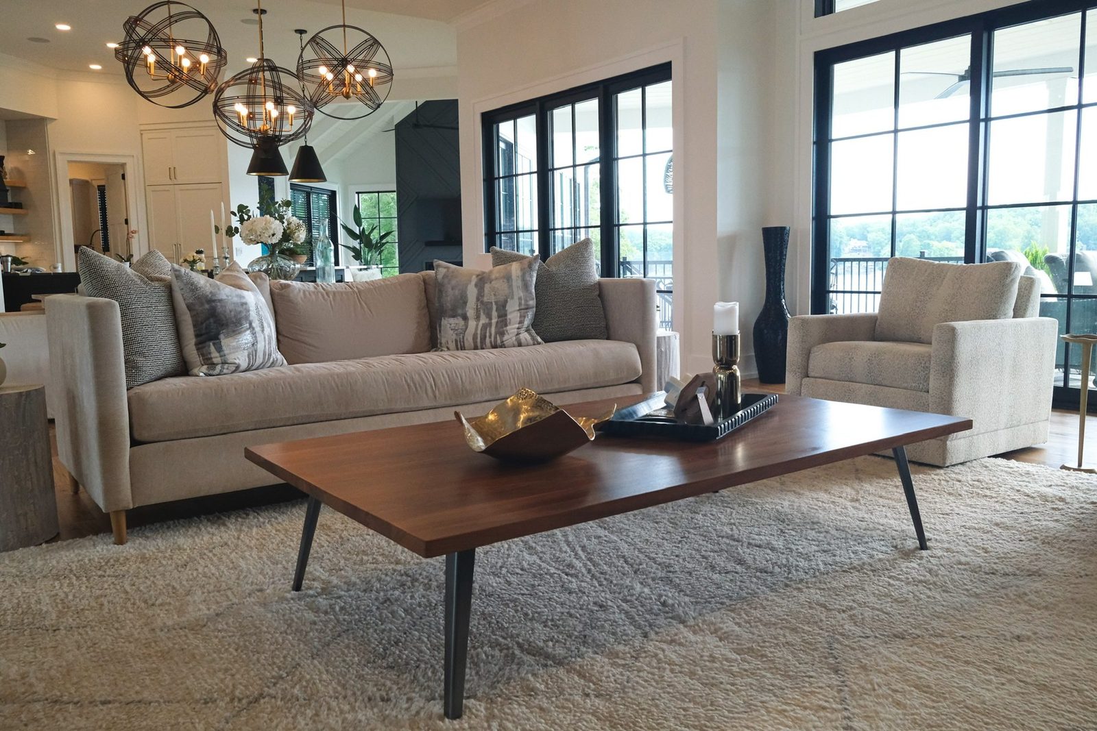 Cream sofa, swivel chair and walnut coffee table in a lakeside living room