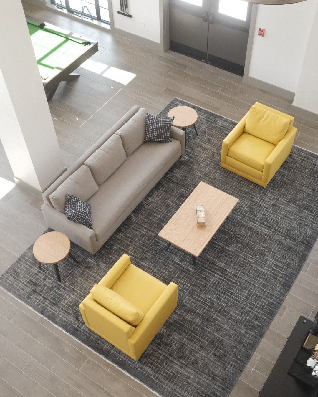 Overhead view of a sofa and two yellow chairs on a gray rug