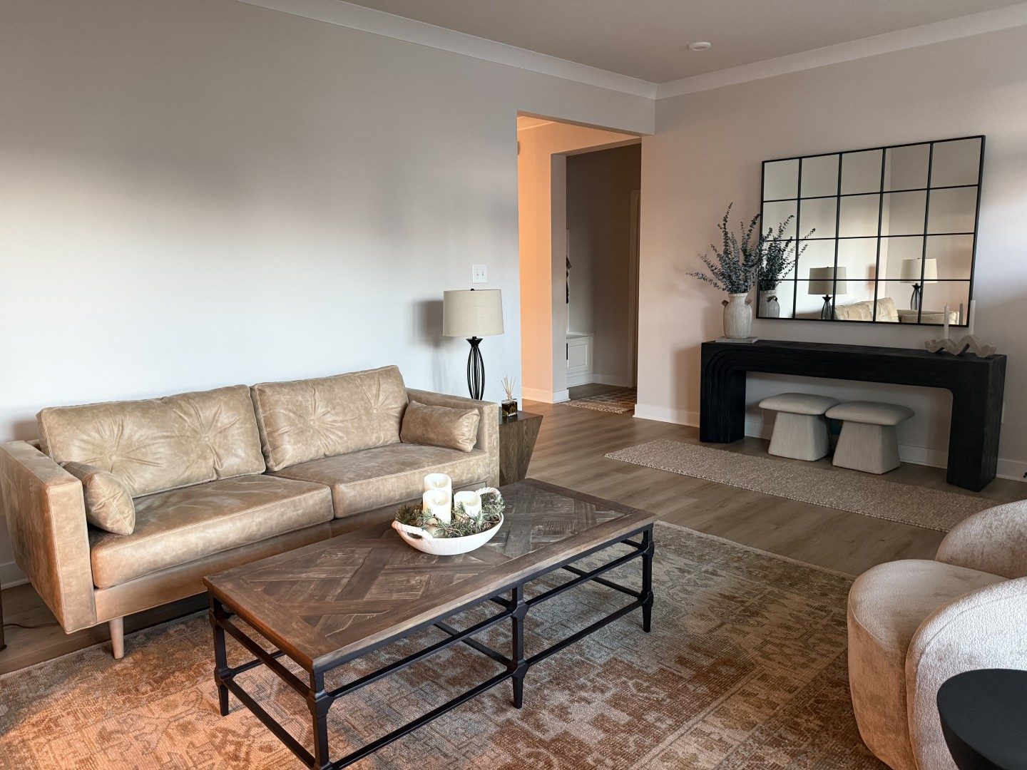 Walnut coffee table with black tapered legs and a brass bowl in front of a cream sofa